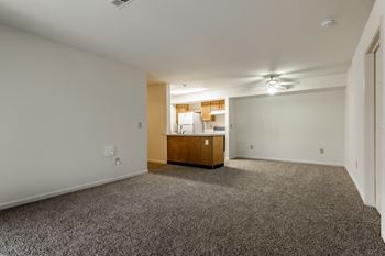 A room with a carpeted floor and a wooden cabinet in the corner.
